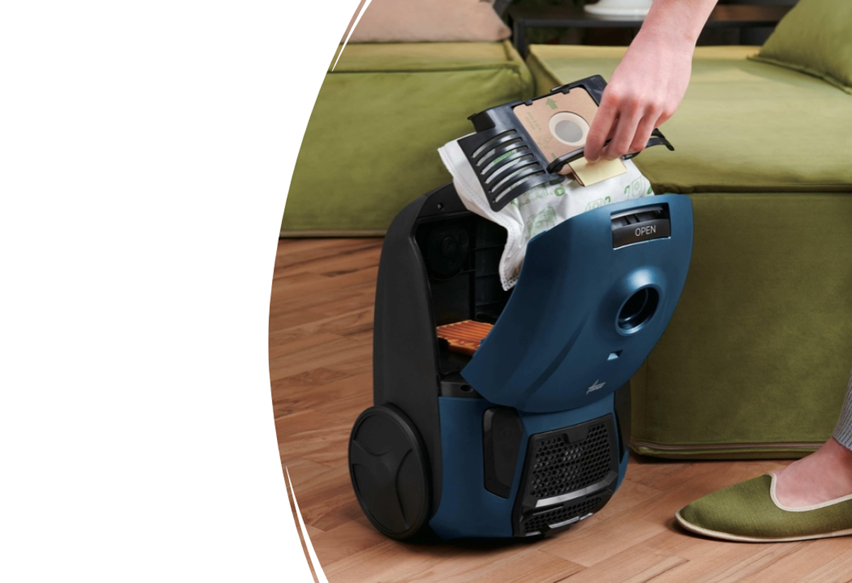 Απεικονίζεται μια γυναίκα να αφαιρεί τη σακούλα από τη σκούπα.